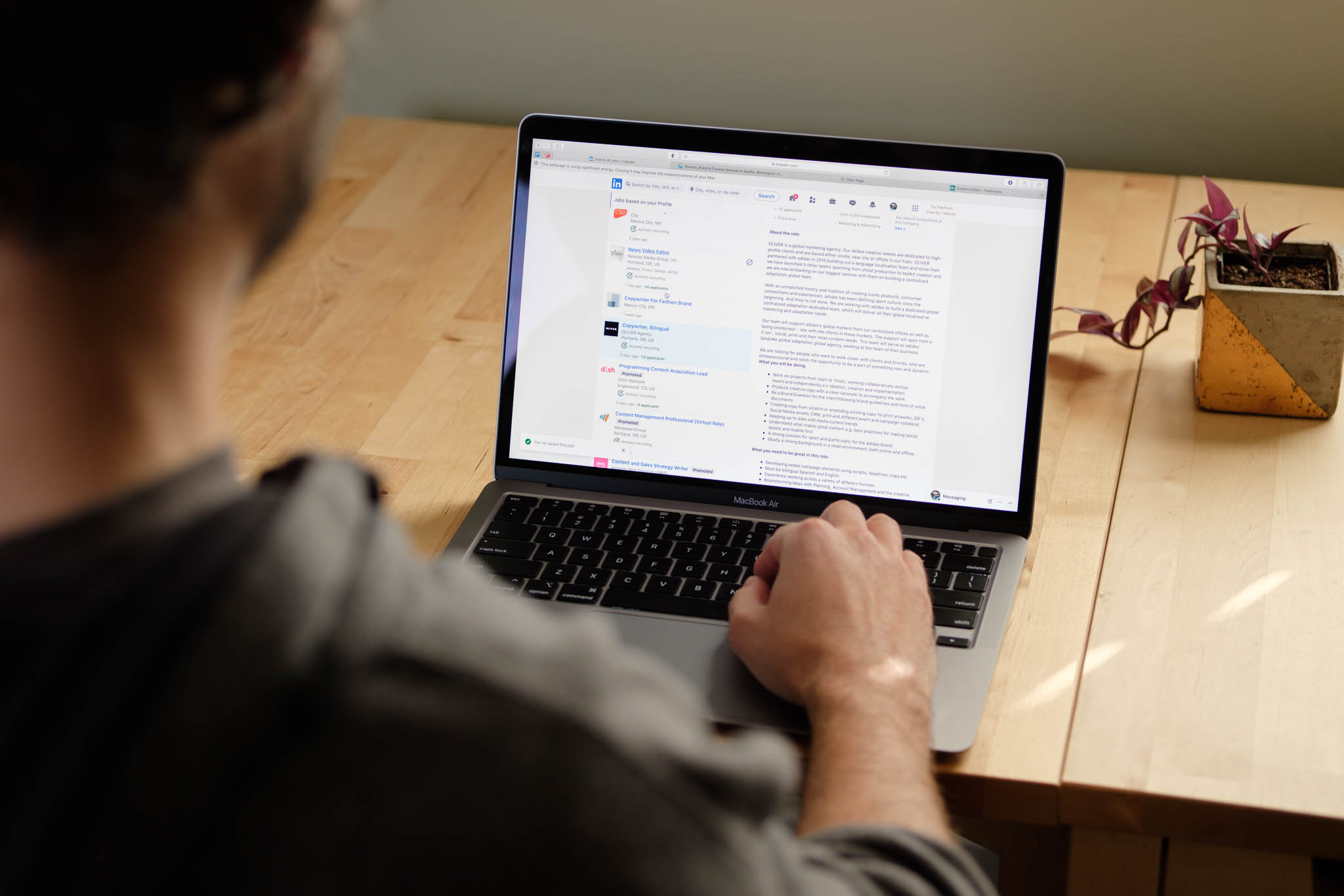 Disheveled man with laptop searching for jobs